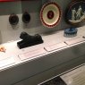 Museum display featuring multiple pieces and correlating information on shelf edge label holders.